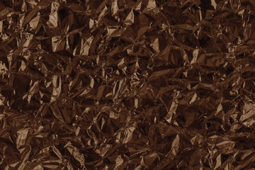 Shiny brown foil texture background, pattern of wrapping paper with crumpled and wavy.