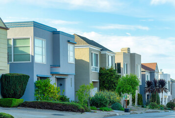 Row of modern urban houses in suburban area of the neighborhood and front yard trees and proch decorations