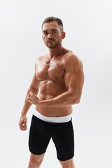 Fototapeta premium Man athletic body bodybuilder in briefs with naked torso abs full-length in the background, fitness classes. Advertising, sports, active lifestyle, competition, challenge concept.