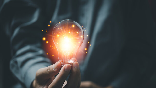 Man holding glowing light bulbs. Inspiration ideas of studying in education with innovative technology and creativity. Success concept of knowledge or cognition inspiration and motivation concept