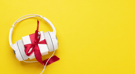Headphones and gift box on yellow