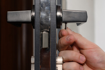 Hex key and installation of door lock and handle, close-up of installation work.