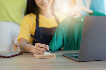 Asian Woman fashion designer cloth tailor creative working for new collection. Happy online store owner preparing an order for shipping