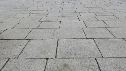 Full frame texture image of grey paving stones leading into the distance