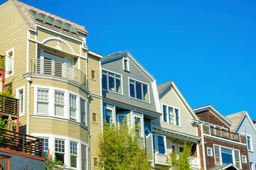 Row of houses in historic districts in San Francisco California in midday sun with clear blue sky background