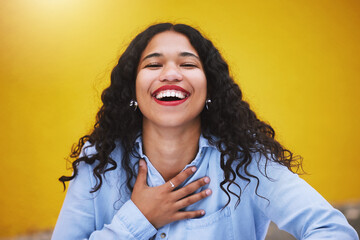 Happy, smile and fun with a woman laughing and joking in studio against a yellow background. Carefree, joy and humor with an attractive young female standing inside on a bright and colorful wall