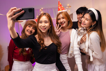 Group of teenager friends enjoying at home night party and taking photo together with phone. - obrazy, fototapety, plakaty