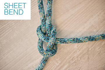 Hiking rope in a knot against a wooden floor background in a studio from above. Strong sheet bend tie, cable or cord equipment to secure safety while mountain climbing or extreme sports for athletes.