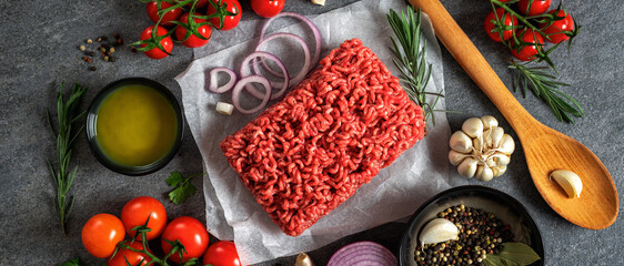 Fresh raw ingredients for cooking healthy food. Minced beef meat with vegetables and spices on dark...