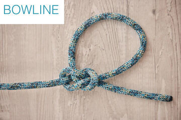 Safety, prevention and hiking rope knot in a bowline against a wooden background, ready to be used in an adventure or rock climbing. Safe, secure and strong safety measure for extreme sports