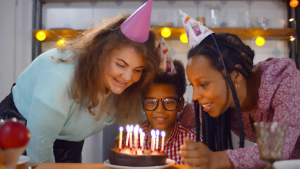 Lesbian diverse family celebrating birthday of adopted African-American son together