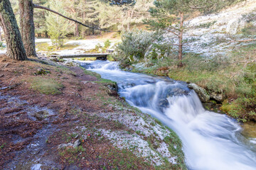 slightly snowy stream in the mountains of the Sierra de Guadarrama in Madrid with the first snow of the year 2022