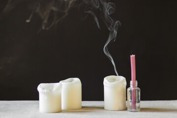 Extinguished paraffin candles with smoke on black background. Blackout in Ukraine and energy crisis in Europe concept.