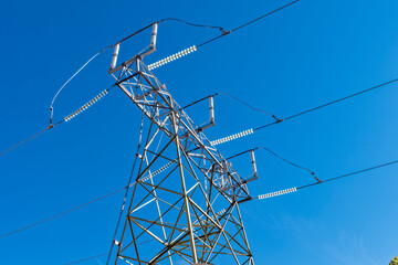 The top of a high tension electrical transmission tower with glass insulators