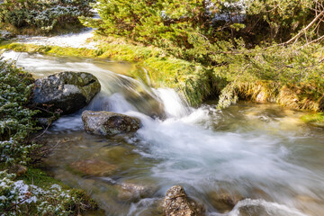 Fototapeta premium slightly snowy stream in the mountains of the Sierra de Guadarrama in Madrid with the first snow of the year 2022