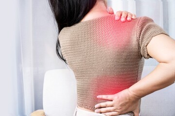 woman suffering from shoulder pain or upper back spreading to the lower back