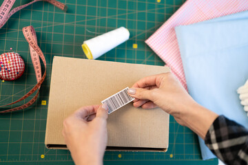 Startup small business SME owner female entrepreneurs packing product shipping order box, labeling delivery package with barcode. Online selling, e-commerce