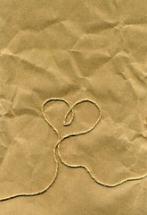 Eco friendly Valentine card. Heart silhouette made with packing twine on a brown paper. Love and connection symbol
