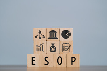 word ESOP with wood building blocks, light gray background. document with numbers on background,...