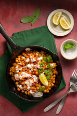 Cooked chickpea in frying pan with curry and spices, homemade vegan chickpeas, healthy food, colorful background
