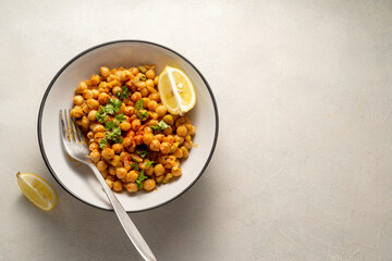 Fototapeta na wymiar Chickpea dish with curry, cooked chickpeas with spices and herbs. Vegetarian food, copy space.