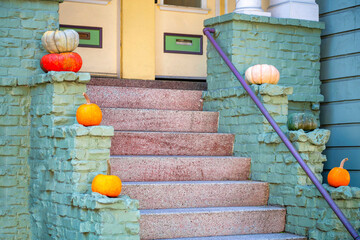 Red cement stairs with green stone brick wall and black metal hand rail with yellow front door with...