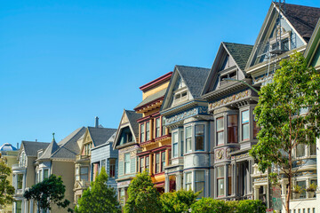 Row of colorful houses in historic downtown San Francisco California in afternoon sun with front yard trees in the city