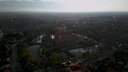 Drone flight over the castle of Fagaras in Romania during afternoon with water reflections - Autumn panorama establishing shot of city of Făgăraș in România  - Transylvania region 2022