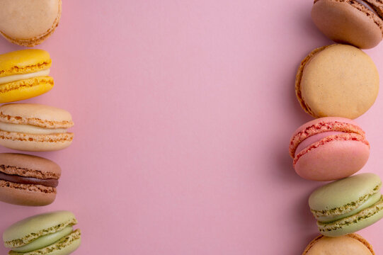 Macaroons colorful cookies. Macarons french sweet dessert, top view, pink background. Copy space