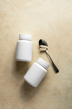 White pill bottles on warm background. Health care food supplements, vitamins and medicaments