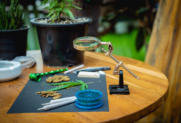 Obraz na płótnie Canvas Joints and buds of medical cannabis and cigarettes on a wooden table
