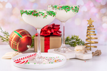 White sugar cookie martini with festive sprinkles rim. Christmas New Year alcohol cocktail with...