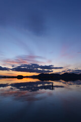 A scene just before sunset on a lake in the middle of winter, a beautiful and hopeful sunset shining through the clouds.