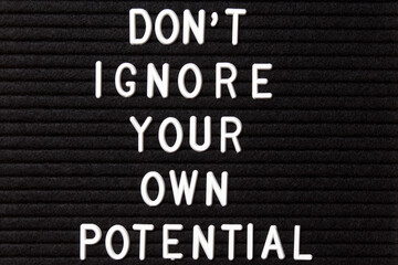 Motivational quote on black letter board. Don't ignore your own potential. Inspirational quote of the day.