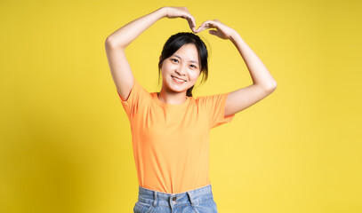 Asian girl posing on yellow background