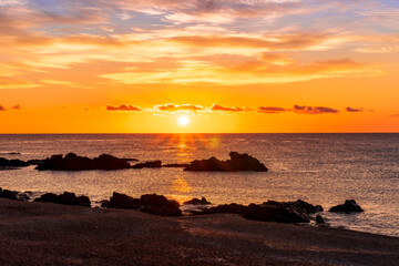 Obraz premium morning or evening landscape with nice beach during sunrise or sunset in sea with amazing isle with rocks and beautiful clouds on background