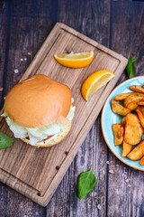 Homemade Salmon Burger with Tartar Sauce and wedges potatoes 