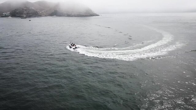 Friends in a yacht circuling in the middle of the ocean in the doast of Peru during summer