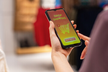 Sales and discounts. Close up of female hand holding smartphone with online store at screen. Concept of online shopping and drop shipping order