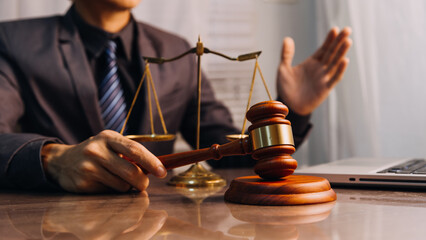 Justice and law concept.Male judge in a courtroom with the gavel, working with, computer and...