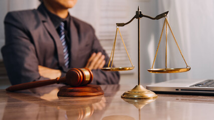 Justice and law concept.Male judge in a courtroom with the gavel, working with, computer and...