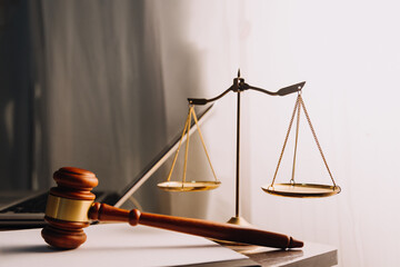 Justice and law concept.Male judge in a courtroom with the gavel, working with, computer and docking keyboard, eyeglasses, on table in morning light