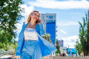 portrait of a business lady in a blue suit walking in the street