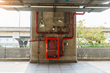 Fire extinguisher and water pump system on the wall, powerful emergency equipment for apartment and...