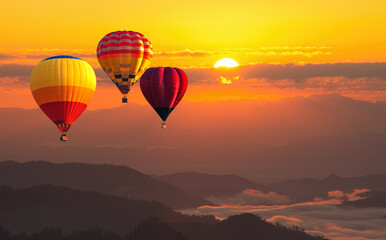 Fototapeta premium color hot air balloon in sky at sunrise time, Colorful hot-air balloons flying in orange sky and sunset. Sport, adventure, transportation,Travel.