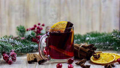 cups with hot mulled wine on a wooden background.