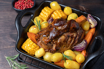 Holiday dinner food Pork shank with baked potatoes and corn, festive food with Christmas New Year decor