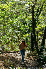Naklejka na ściany i meble Chica joven delgada caminando por sendero de bosque