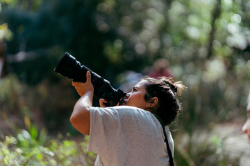 Chica joven con cámara de fotografía haciendo fotos en la naturaleza