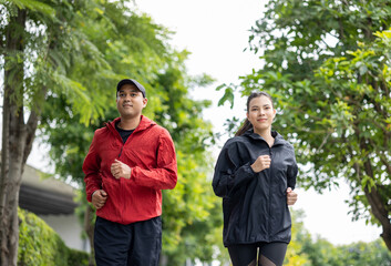 Couple jogging and running outdoors in nature. Happy Man woman wearing sportswear jogging in the...